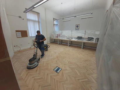Operater mašine za brušenje parketa priprema parket za lakiranje
