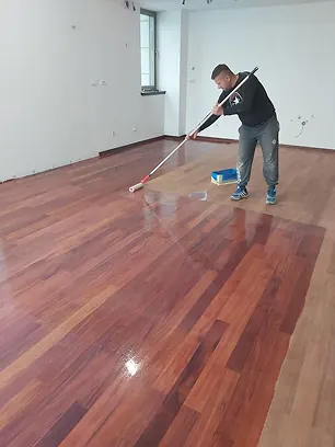 Stručnjak za podove postavlja zaštitni lak na parket