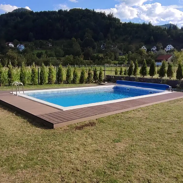 Otvoreni bazen u dvorištu kuće sa kvalitetnom WPC podlogom postavljenom oko bazena