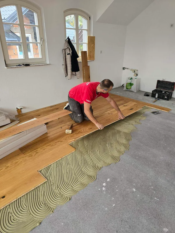 Profesionalna ugradnja modernog parketa - majstor precizno postavlja parket